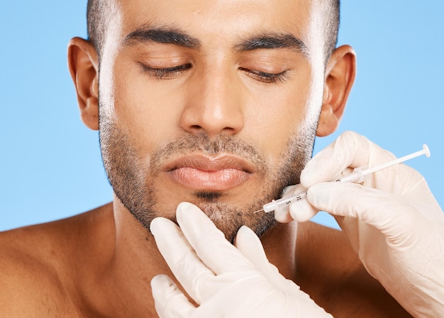 Beauté faciale et botox avec visage d'homme pour la chirurgie plastique esthétique et soins de la peau Injection médicale prp et spa avec modèle sur fond bleu pour traitement dermatologique ou remplissage de cosmétiques