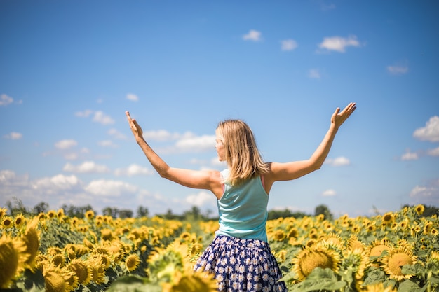 Beauté femme ensoleillée sur champ de tournesol jaune Concept de liberté et de bonheur. Fille heureuse à l'extérieur