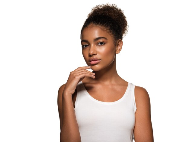 Beauté femme peau noire visage souriant modèle touchant son visage. Isolé sur blanc.