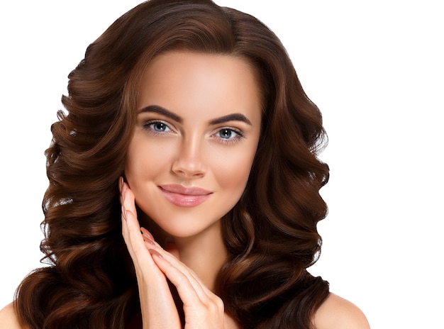 Beauté femme peau saine longue brune coiffure manucure ongles isolés sur blanc. Prise de vue en studio.