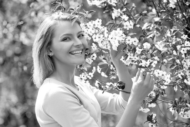 Beauté femme tenant des branches d'arbre en fleurs