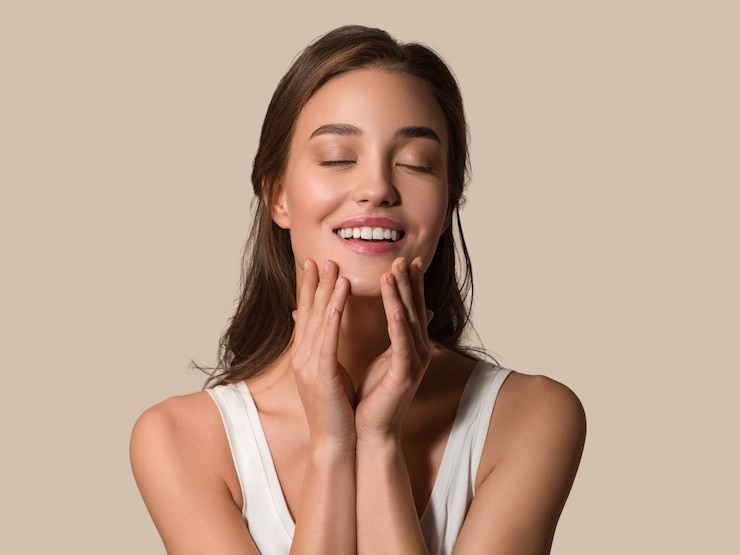 Photo beauté femme visage sain soins de la peau femme belle femme toucher son visage. fond de couleur marron