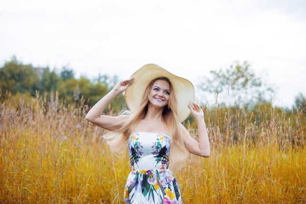 Beauté des femmes dans un chapeau de paille seul avec la nature