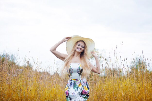 Beauté des femmes dans un chapeau de paille seul avec la nature