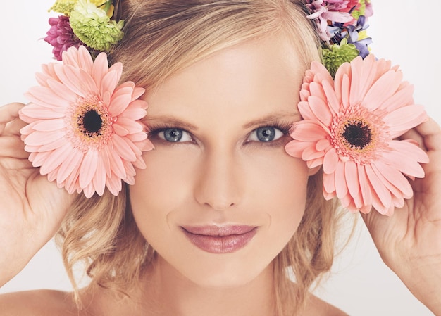 Beauté florale Une jeune femme avec un arrangement de fleurs dans ses cheveux souriant à la caméra