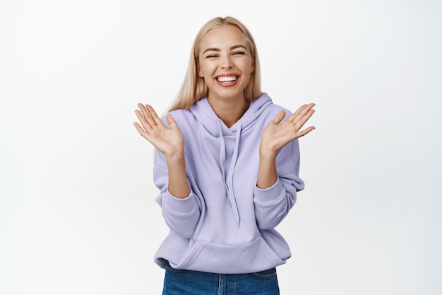 Beauté Heureuse jeune mannequin montrant un sourire blanc et une émotion positive riant et souriant à la caméra sur fond blanc