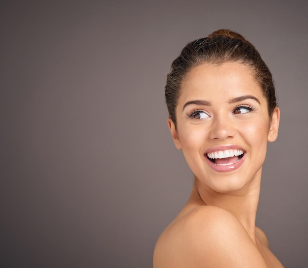 Beauté inégalée par tout autre Studio photo d'une belle jeune femme à la peau impeccable posant sur un fond gris