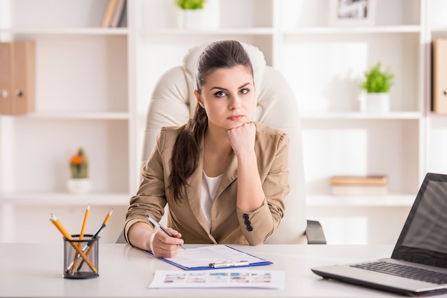 Beauté jeune femme assise au bureau.