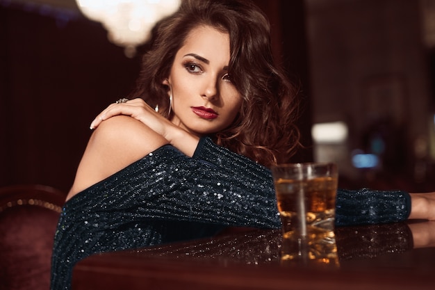 Beauté jeune femme brune assise au bar