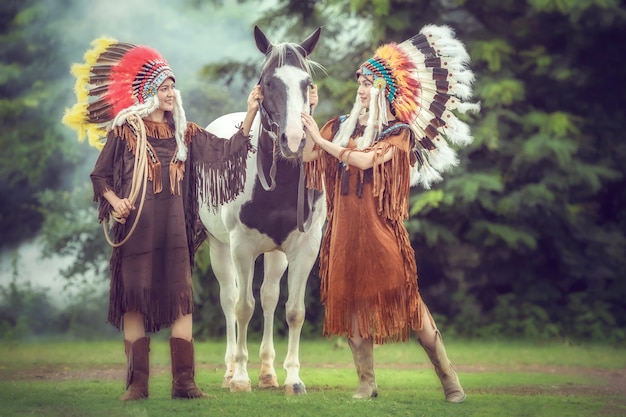 Beauté jeunes filles asiatiques avec femme amérindienne et marche avec cheval de peinture américain en Thaïlande.