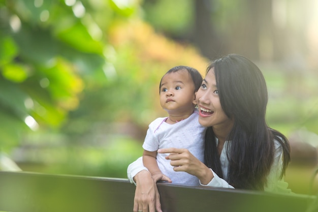 Beauté maman et son enfant jouant ensemble dans le parc