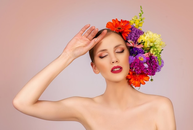 Beauté et maquillage portrait de mannequin avec des fleurs en fleurs