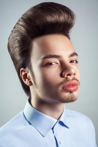 Beauté de mode coiffure homme sur fond gris