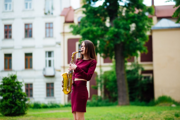 Beauté et mode, musique. Jolie femme avec saxophone.