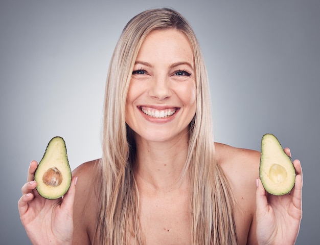 Beauté de la peau ou des cheveux avocat pour portrait de femme en studio avec cosmétique naturelle et éclat de shampooing Visage de modèle esthétique avec des fruits sur fond gris pour coiffeur ou produit durable