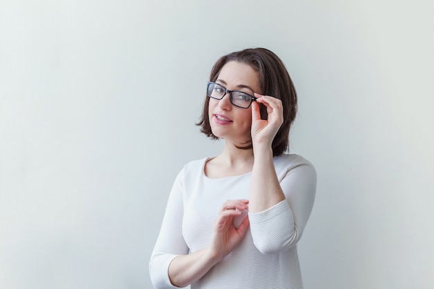 Beauté portrait simple jeune femme brune souriante à lunettes isolé sur blanc