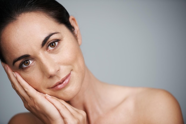 Beauté sans date de péremption Portrait en studio d'une belle femme d'âge moyen touchant son visage