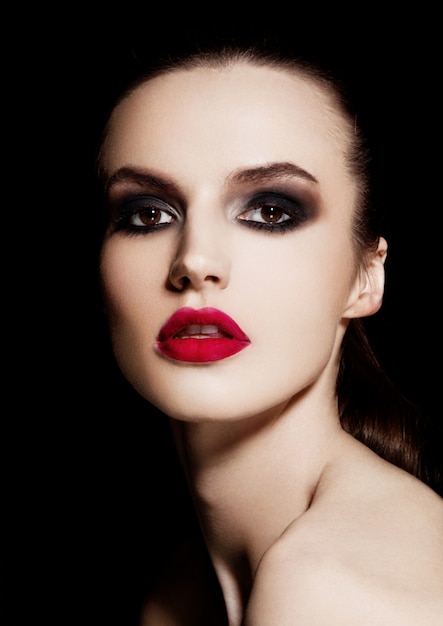 Beauté smokey eyes lèvres rouges maquillage mannequin sur fond noir