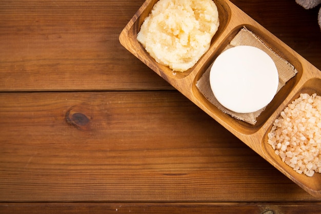 Photo beauté, spa, soins du corps, cosmétiques naturels et concept de bien-être - gros plan de savon au sel rose de l'himalaya et gommage dans un bol en bois sur la table