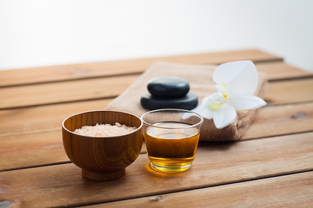 beauté, spa, soins du corps, cosmétiques naturels et concept - gros plan de sel rose avec du miel en verre et serviette de bain sur table en bois