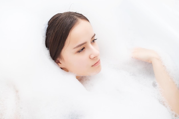 Beauté spa soins personnels Jeune femme se détend dans le bain avec de la mousse