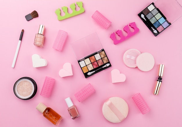 Beauty Spa Concept Féminin. Différents produits cosmétiques Make Up Beauty Care Essentials sur Flat Lay Pink Background. Vue de dessus. Au dessus.