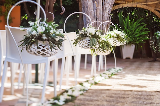 Beaux arrangements floraux de mariage le long de l'allée