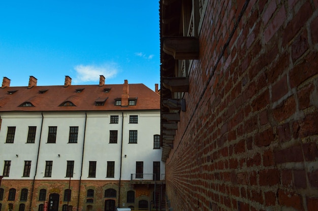 Beaux bâtiments de faible hauteur européens médiévaux historiques jaunes avec un pignon de toit de tuiles rouges