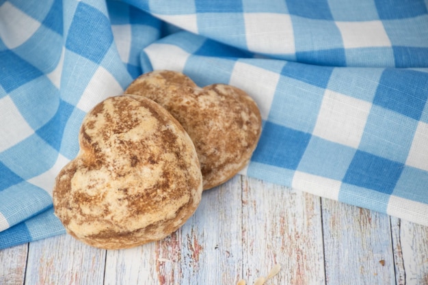 De beaux biscuits au pain d'épice en forme de cœur sont disposés avec de la crème sure Délicieux biscuits aux épillets