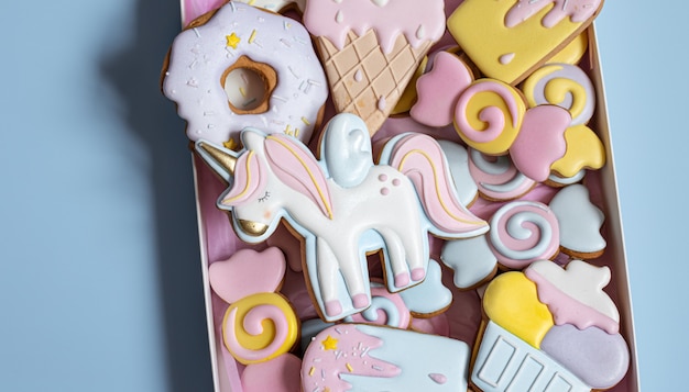 Beaux biscuits de pain d'épice pour la fête des enfants en forme de licorne et de bonbons, à plat.