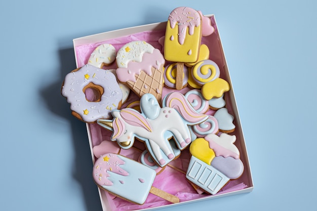 Beaux biscuits de pain d'épice pour la fête des enfants en forme de licorne et de bonbons, à plat.