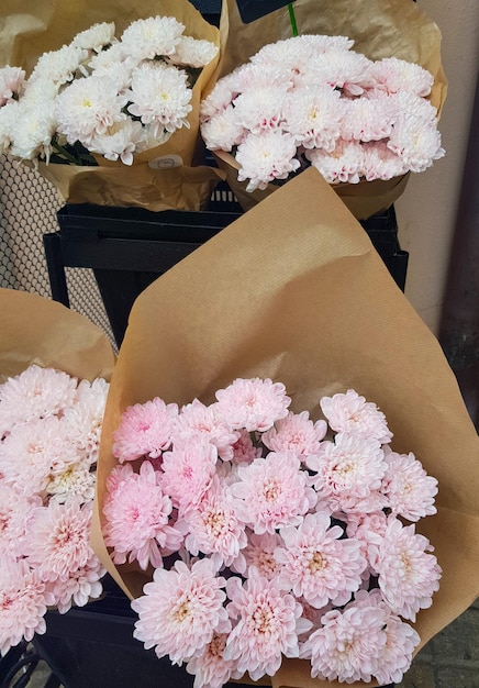 Beaux bouquets cadeaux de chrysanthèmes en papier kraft brun sur le comptoir d'un fleuriste vertical