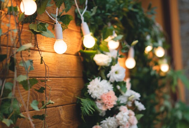 Photo beaux bouquets de fleurs sur le fond d'une planche de bois et de guirlandes