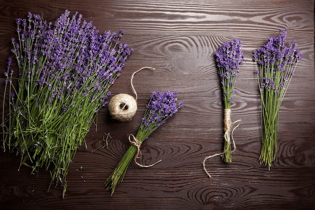 Beaux bouquets de fleurs de lavande pourpre sur fond de bois foncé, vue du dessus