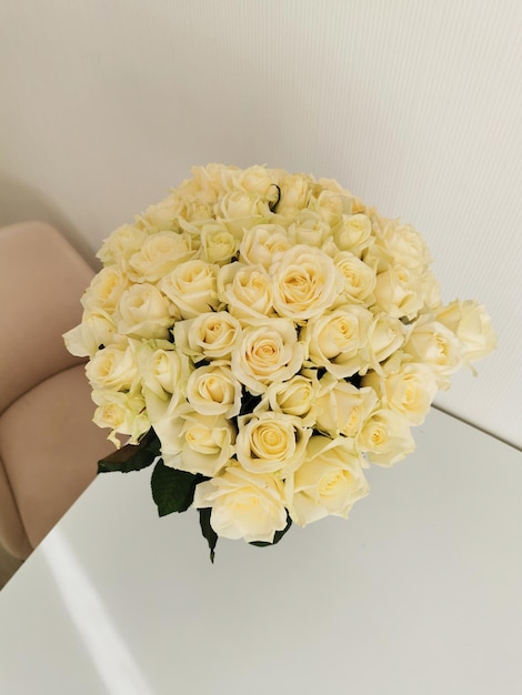 Beaux bouquets de roses blanches dans un vase en verre sur une table blanche et intérieur 51 roses