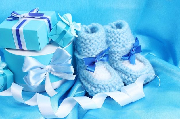 de beaux cadeaux et des bottes de bébé en soie bleue