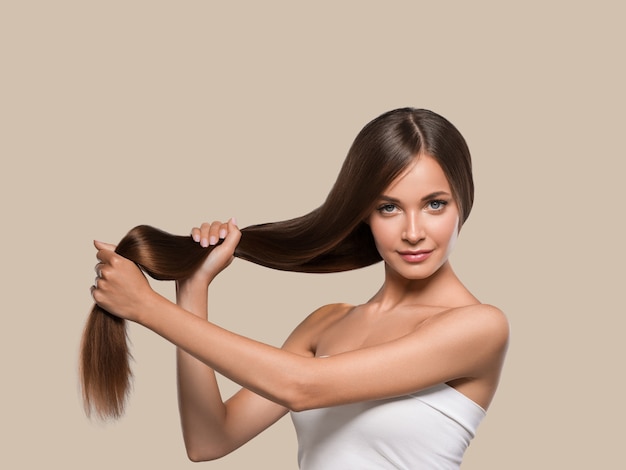 Beaux cheveux lisses longue brune coiffure femme peau saine. Fond de couleur. brun