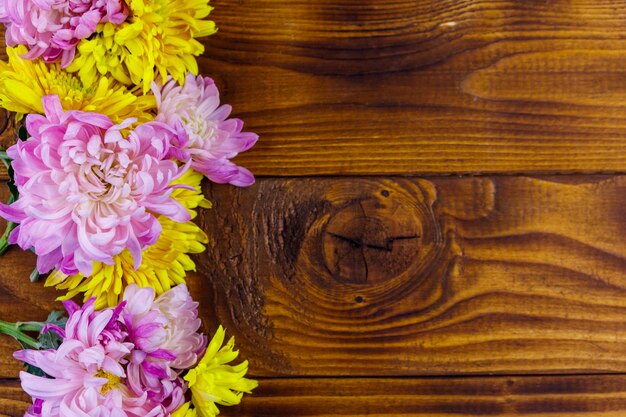 Beaux chrysanthèmes sur fond de bois. Vue de dessus, espace de copie