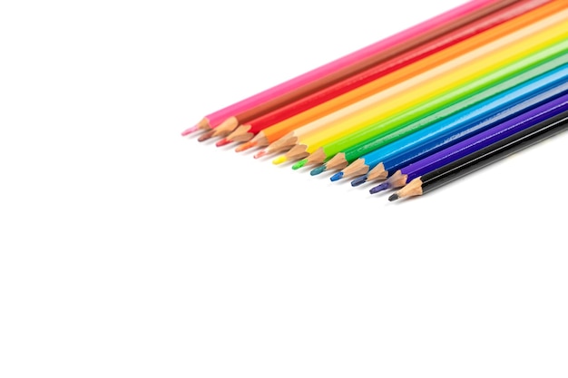 De beaux crayons de couleur émoussés sont disposés ensemble prêts à l'emploi c'est sur le fond blanc