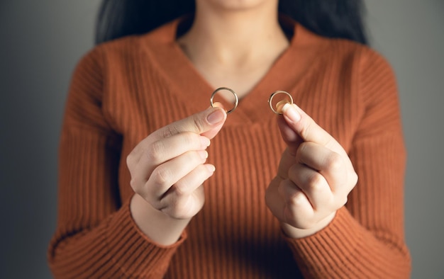 Beaux doigts féminins tenant des anneaux de mariage