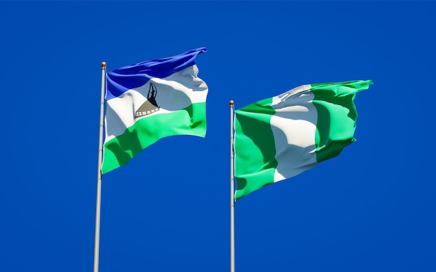 Beaux drapeaux d'état national du Lesotho et du Nigéria ensemble sur ciel bleu