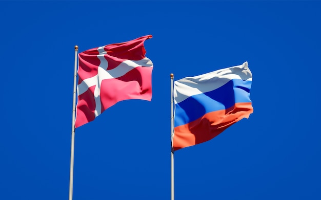 Beaux drapeaux nationaux du Danemark et de la Russie ensemble sur le ciel bleu. Illustration 3D