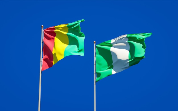 Beaux drapeaux nationaux de la Guinée et du Nigéria ensemble sur ciel bleu