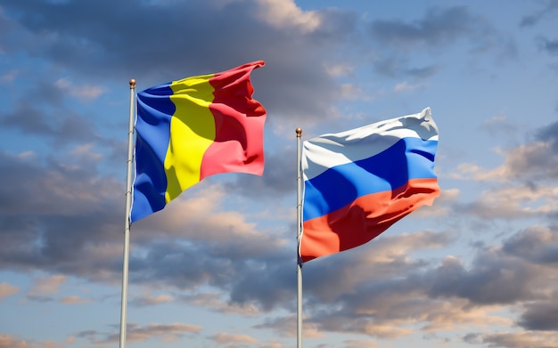 Beaux drapeaux nationaux de la Roumanie et de la Russie ensemble sur le ciel bleu. Illustration 3D