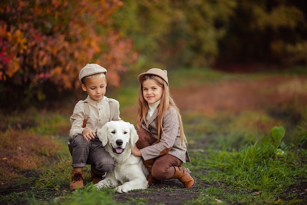 Beaux enfants heureux frère et soeur promènent leur chien retriever