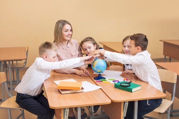 Les beaux enfants sont des étudiants ensemble dans une salle de classe à l'école reçoivent l'éducation avec l'enseignant