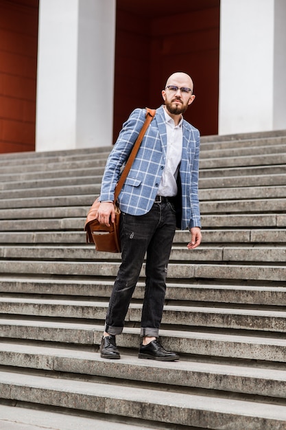 Beaux experts en marketing masculin en costume formel élégant marchant sur la rue de la ville pour visiter la conférence de réunion