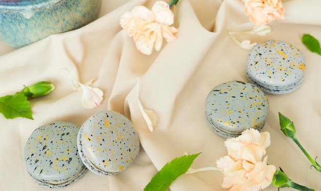 Beaux gâteaux de macaron et fleurs d'oeillets sur la table