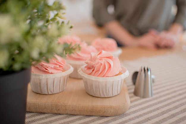 De beaux gâteaux roses sont sur la table, sur un support