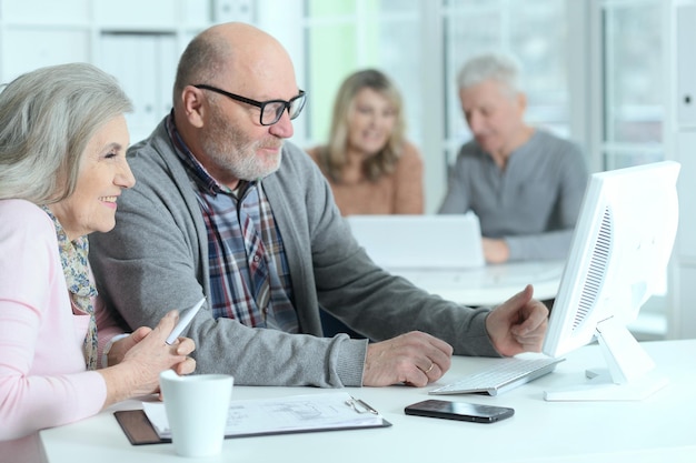 Beaux hommes d'affaires seniors posant et travaillant au bureau